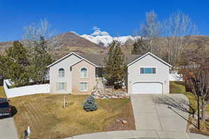 View of front of home featuring a mountain view, a garage, and driveway