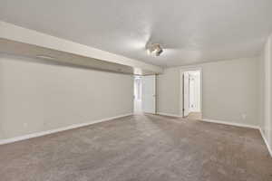 Large Basement bedroom with carpet floors and a textured ceiling