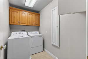 Laundry room featuring washer and clothes dryer, a textured ceiling, and cabinet space