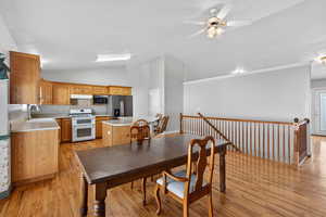 Dining space with light wood-type flooring, a ceiling fan, and lofted ceiling