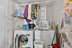 Laundry area in ADU featuring separate washer and dryer and a textured wall