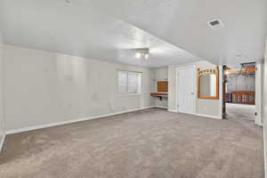 Large Basement bedroom with carpet floors and a textured ceiling