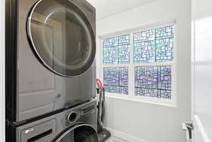 Laundry area with stacked washer / dryer and baseboards