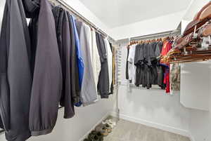 Walk in closet featuring light carpet