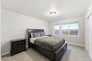 Bedroom with light carpet and a textured ceiling