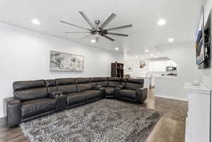 Living room featuring recessed lighting, dark wood-style flooring, and ceiling fan