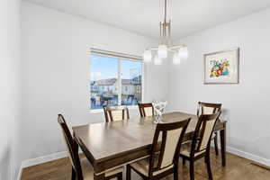 Dining area with dark wood finished floors and hanging lights