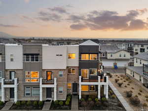 View of front facade featuring brick siding, a balcony, stucco siding, and a residential view