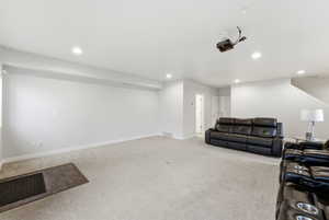 Living area with light colored carpet and recessed lighting