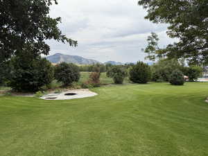 View of green lawn featuring a mountain view to the east and a fire pit
