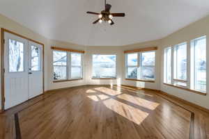 sunroom with wood flooring and vaulted ceiling