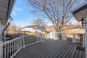 Wooden terrace featuring an outdoor structure, a yard, and a residential view