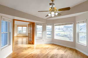 Sunroom featuring a ceiling fan, light wood-style floors, and french doors