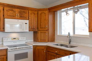 Kitchen with white appliances, wood finish cabinets