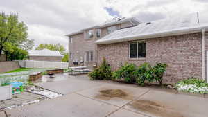 Rear view of house featuring a fire pit, a patio, brick siding, and roof with shingles