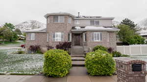 View of front of house featuring a mountain view, roof mounted solar panels, and brick siding