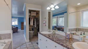 Full Bath featuring a Bath, Double Vanity, and a Spacious Coset