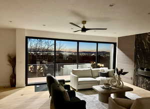 Living area with ceiling fan and wood finished floors
