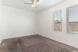 Spare room with dark carpet and ceiling fan