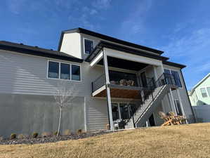 Rear view of house featuring a patio and a yard