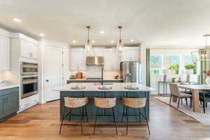 Two tone kitchen with quartz counters, hardwood floors and GE Cafe appliances.