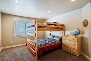 Bedroom with dark colored carpet and recessed lighting
