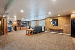 Carpeted living room featuring a fireplace, recessed lighting, a textured ceiling, and built in shelves