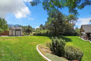 Fenced backyard with a patio area and a storage shed