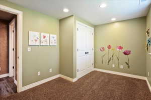 Hall with dark carpet and recessed lighting