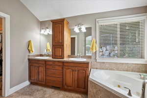 Full bathroom with double vanity, a whirlpool tub, light tile patterned floors, and a spacious closet