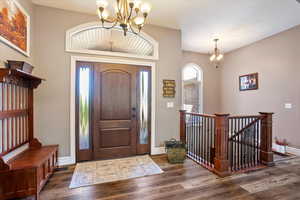 Foyer with a chandelier and dark wood-style floors