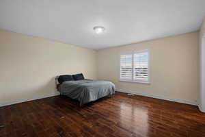 Bedroom featuring baseboards and dark wood finished floors
