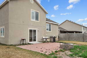 Back of house featuring an outdoor fire pit, a patio, and stucco siding