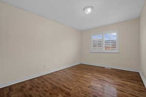 Empty room with dark wood-style floors and baseboards