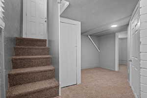 Staircase with carpet, a textured ceiling, and recessed lighting