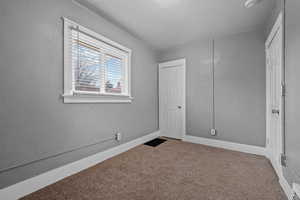 Unfurnished bedroom with carpet flooring and baseboards