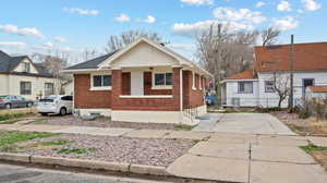 Bungalow-style house with brick siding and a porch