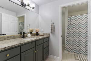 Bathroom with a shower with curtain, vanity, and light tile patterned flooring