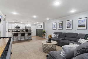 Living area featuring crown molding, recessed lighting, and laminate finished floors