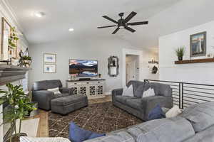 Living room featuring laminate floors, vaulted ceiling, a ceiling fan, and recessed lighting