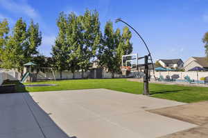 View of sport court featuring a playground, a fenced backyard, a swimming pool, basketball court, and a patio