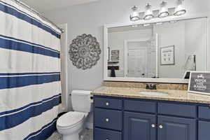 Bathroom featuring curtained shower and vanity