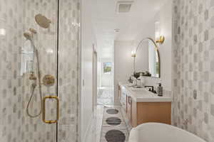 Full bathroom with double vanity, a soaking tub, a shower stall, and a textured ceiling