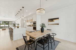 Dining space featuring light wood-style flooring and a chandelier