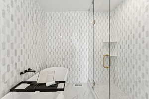 Full bath with a shower stall and a freestanding tub