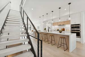 Staircase with wood finished floors and recessed lighting