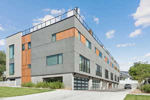 View of apartment building / complex with a garage and driveway