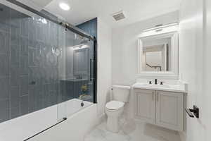 Bathroom with vanity, enclosed tub / shower combo, and light marble finish floors