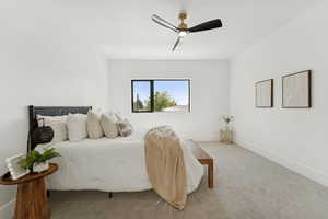 Carpeted bedroom featuring baseboards and ceiling fan