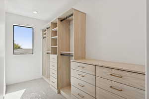 Walk in closet featuring light carpet
